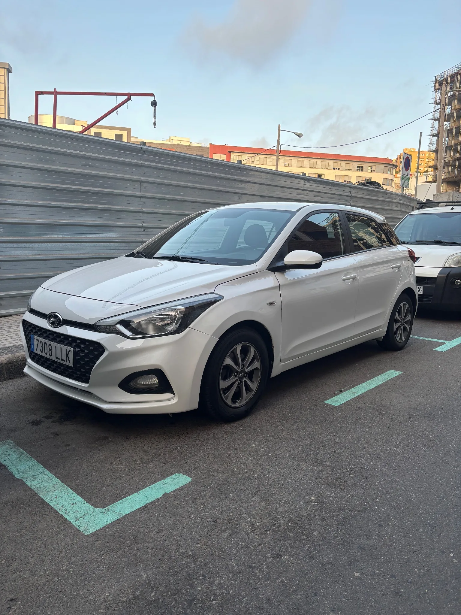 Antes: Hyundai i20 blanco aparcado en la calle, foto hecha con el móvil